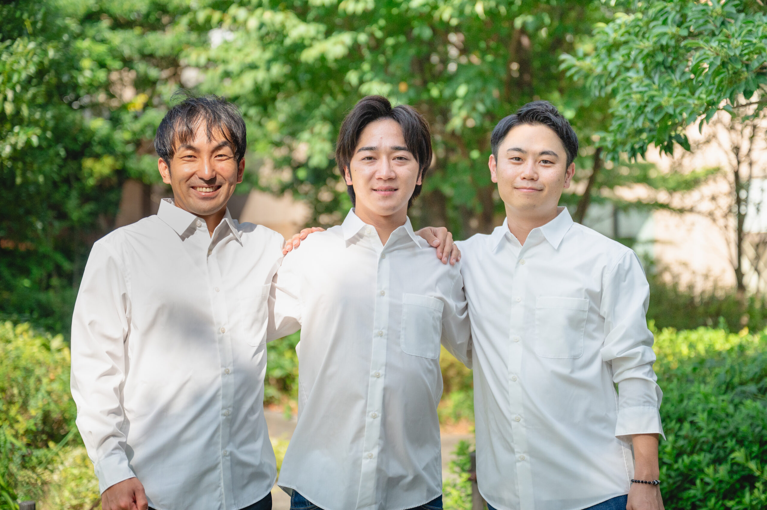 肩を組むメンバー３名：コミュニティの一体感